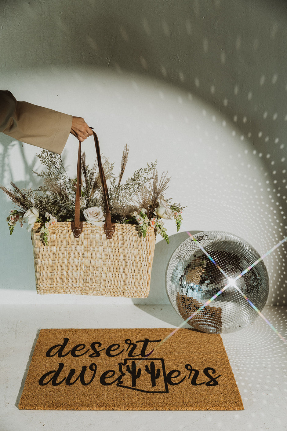 Curated real estate gift with custom doormat and basket of flowers