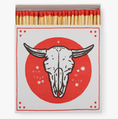 Load image into Gallery viewer, Vintage oversized matchbox with cow skull in white over a red circle. The words "Run Free. Be Wild" are printed on it.
